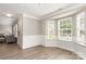 Living room with wood-look flooring, wainscoting, and a bay window letting in plenty of light at 6608 Pattonsburg Dr, Charlotte, NC 28213