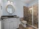 Bathroom featuring a glass shower with brown tiling, a dark countertop, and a round mirror at 6742 Charlotte Hwy, York, SC 29745