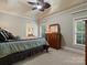 Bedroom with neutral carpeting, ceiling fan, dresser with mirror and window with wooded outdoor view at 6742 Charlotte Hwy, York, SC 29745