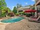 A backyard swimming pool with patio, waterfall feature, manicured landscaping, and lounge chairs at 6742 Charlotte Hwy, York, SC 29745