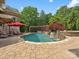 Inviting pool area featuring a waterfall, lush landscaping, lounge chairs and umbrellas for relaxing by the water at 6742 Charlotte Hwy, York, SC 29745