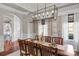 An elegant dining room features a modern chandelier, large window, and seating for eight at 8301 Caesars Head Dr, Waxhaw, NC 28173