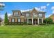 Charming two-story brick home featuring a welcoming front porch and manicured landscaping at 8301 Caesars Head Dr, Waxhaw, NC 28173