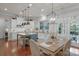 Bright kitchen featuring white cabinets, an island with seating, and an adjacent dining area at 8301 Caesars Head Dr, Waxhaw, NC 28173