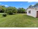 Scenic backyard view with a white brick house, green lawn, and a classic wooden fence at 9135 Stokes Ferry Rd, Salisbury, NC 28146