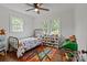 Bright bedroom with hardwood floors, ceiling fan, and two windows at 9135 Stokes Ferry Rd, Salisbury, NC 28146