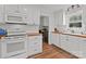 Updated kitchen featuring white cabinetry, subway tile backsplash, and hardwood floors at 9135 Stokes Ferry Rd, Salisbury, NC 28146