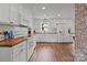 Well-lit kitchen featuring white cabinets, modern appliances, and hardwood floors at 9135 Stokes Ferry Rd, Salisbury, NC 28146