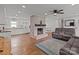 Open-concept space featuring a brick fireplace, hardwood floors, and an adjacent kitchen at 9135 Stokes Ferry Rd, Salisbury, NC 28146
