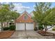 Home with a two-car garage and brick exterior surrounded by lush green trees at 10207 Garmoyle St, Charlotte, NC 28277