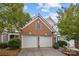 A large two car garage showcasing a brick facade with light shrubbery and a double driveway at 10207 Garmoyle St, Charlotte, NC 28277