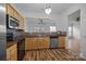 Well-lit kitchen with stainless steel appliances, wood cabinets, and pass-through to another room at 10207 Garmoyle St, Charlotte, NC 28277