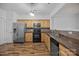 Well-lit kitchen with stainless steel appliances, wood cabinets, and backsplash at 10207 Garmoyle St, Charlotte, NC 28277