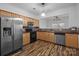 Well-lit kitchen with stainless steel appliances, wood cabinets, and pass-through to another room at 10207 Garmoyle St, Charlotte, NC 28277