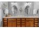 Bathroom featuring dual sinks, wooden cabinets, decorative mirrors, and neutral countertops for a luxurious feel at 10405 Scotland Ave, Indian Land, SC 29707