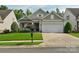 Inviting one-story home featuring a lush green lawn, an attached two-car garage, and manicured landscaping at 10405 Scotland Ave, Indian Land, SC 29707