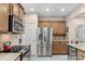 Well-lit kitchen features stainless steel appliances, wooden cabinetry, and granite countertops at 10405 Scotland Ave, Indian Land, SC 29707