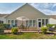 Charming patio with brick pavers, table and chairs, sun umbrella, and well-manicured landscaping for outdoor living at 10405 Scotland Ave, Indian Land, SC 29707