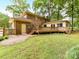 View of deck and the back of the home, along with a spacious grassy lawn at 1049 Regency Dr, Charlotte, NC 28211