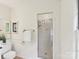 Bright bathroom featuring a glass shower, tiled floors, a toilet, and a gold towel rack at 1049 Regency Dr, Charlotte, NC 28211