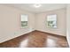 Inviting bedroom with two large windows offering natural light and beautiful hardwood flooring at 1049 Regency Dr, Charlotte, NC 28211