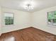 Sunlit bedroom with hardwood floors and dual windows overlooking the neighborhood at 1049 Regency Dr, Charlotte, NC 28211