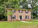 Charming brick two-story home with blue shutters, mature trees, and manicured front yard at 1049 Regency Dr, Charlotte, NC 28211