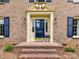 Welcoming entryway featuring a blue front door, brick steps, and decorative pillars at 1049 Regency Dr, Charlotte, NC 28211