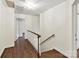 Upstairs hallway with wood floors, white walls, and an attractive wooden banister at 1049 Regency Dr, Charlotte, NC 28211