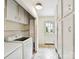 Bright laundry room with white cabinets, tile floors, and a convenient exterior door at 1049 Regency Dr, Charlotte, NC 28211