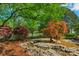 Landscaped backyard with rock pond and vibrant foliage at 10508 Old Wayside Rd, Charlotte, NC 28277