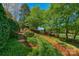 Landscaped backyard with brick steps, lush greenery, and views of the golf course at 10508 Old Wayside Rd, Charlotte, NC 28277
