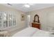 Bedroom featuring a comfy bed, shuttered window, an antique dresser with mirror creating a cozy retreat at 10508 Old Wayside Rd, Charlotte, NC 28277