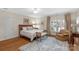 Inviting bedroom with hardwood floors, neutral colors, a plush rug, and shuttered windows creating a relaxing ambiance at 10508 Old Wayside Rd, Charlotte, NC 28277