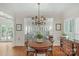 Charming dining room with chandelier and view into the bright living room with many windows at 10508 Old Wayside Rd, Charlotte, NC 28277