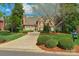 Charming brick home featuring a lush front lawn, circular driveway, and manicured landscaping at 10508 Old Wayside Rd, Charlotte, NC 28277