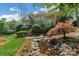Stunning brick home with arched windows, lush landscaping, and a serene pond at 10508 Old Wayside Rd, Charlotte, NC 28277