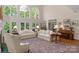 Bright living room featuring soaring windows, hardwood floors, and comfortable seating at 10508 Old Wayside Rd, Charlotte, NC 28277