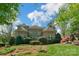 A brick home with large windows and a lush, landscaped backyard on a bright, sunny day at 10508 Old Wayside Rd, Charlotte, NC 28277