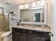 Bathroom featuring double sink with granite countertop and walk-in shower at 10800 Alabaster Dr, Davidson, NC 28036