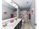 Bathroom featuring double sink, floral shower curtain, and neutral tile flooring at 10800 Alabaster Dr, Davidson, NC 28036