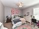 Cozy bedroom with a floral accent wall, fan and bright, natural light from the window at 10800 Alabaster Dr, Davidson, NC 28036