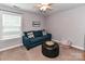 Cozy bedroom with a blue sofa, ottoman, and ceiling fan at 10800 Alabaster Dr, Davidson, NC 28036