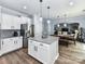 Open-concept kitchen with white cabinets, island, and stainless fridge, seamlessly flowing into the dining area at 10800 Alabaster Dr, Davidson, NC 28036