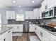 A well-lit kitchen features white cabinets, stainless appliances, gas range, and a gray tiled backsplash at 10800 Alabaster Dr, Davidson, NC 28036