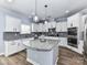 Bright kitchen features white cabinets, stainless appliances, a gray backsplash, and a large center island at 10800 Alabaster Dr, Davidson, NC 28036