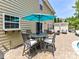 Inviting patio area with dining set and vibrant blue umbrella, perfect for outdoor entertaining at 10800 Alabaster Dr, Davidson, NC 28036