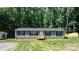 Inviting single-story home featuring light gray siding, dark blue shutters, and a wooden porch with manicured front lawn at 110 Lambert Ln, Statesville, NC 28677