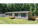 Welcoming home with gray siding, complemented by a wooden porch and lush green lawn; peaceful and inviting at 110 Lambert Ln, Statesville, NC 28677