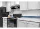 This kitchen boasts gray cabinets, modern appliances, and countertops, with a hood vent above the stove at 110 Lambert Ln, Statesville, NC 28677